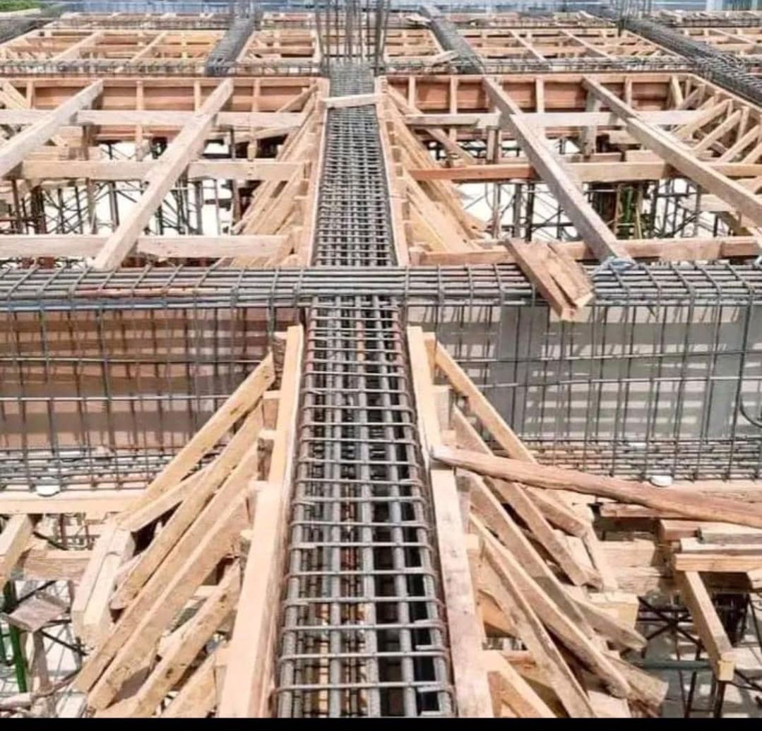 Coffrage bois et ferraillage des poutres et du plancher d'un bâtiment en construction